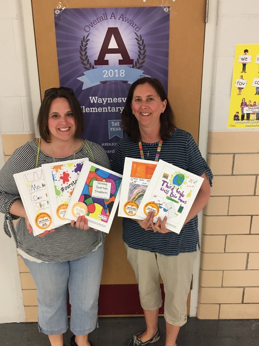 two people holding colorful drawings